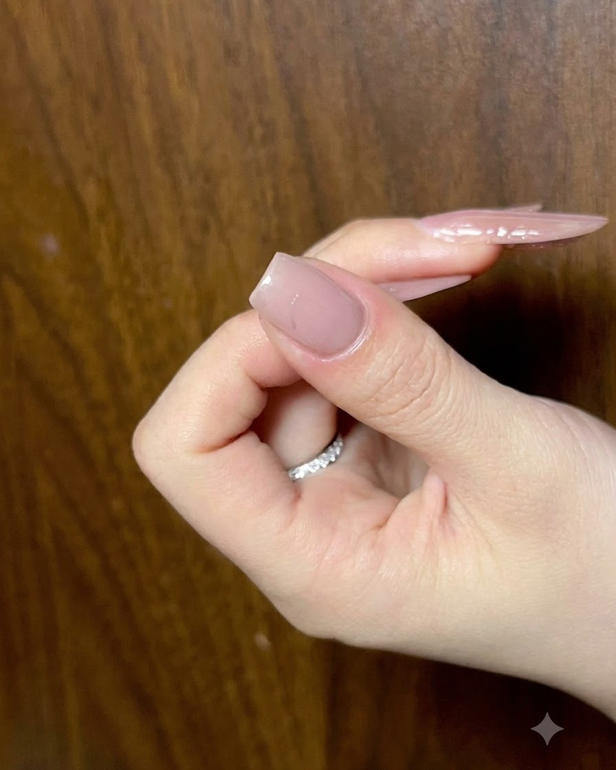 Nahaufnahme eines Fingernagels, der unter einer Lampe ausgehärtet wird, um das mittlere Detail zu fixieren.