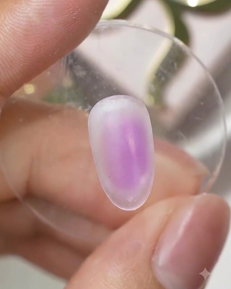 Eine ausgehärtete Nageloberfläche mit einem zarten, violetten Ombré-Farbverlauf in der Mitte des Nagels.