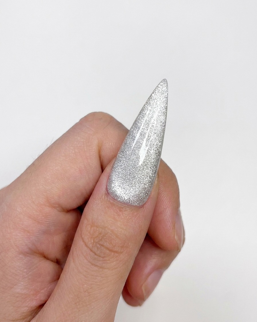 Eine fertiggestellte Cat-Eye-Nagelspitze mit ausgehärtetem, glänzendem Finish und zentriertem Highlight.