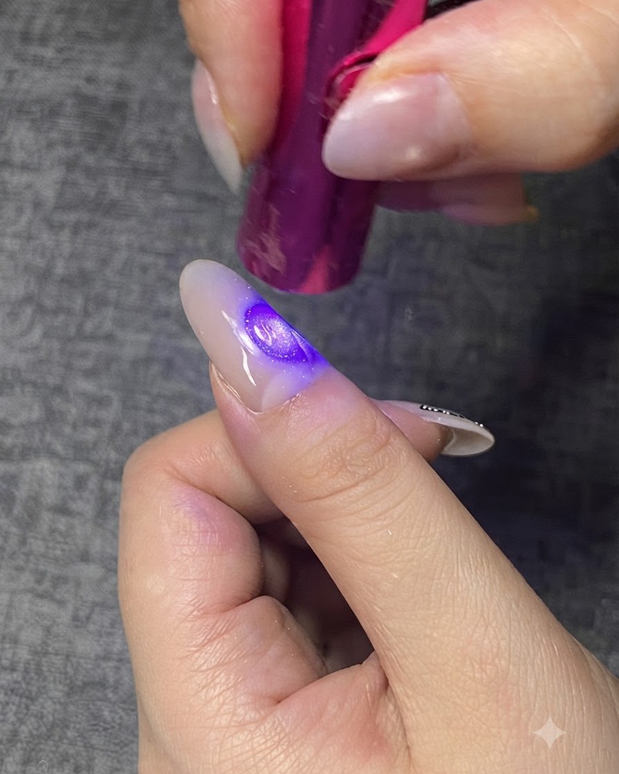 Eine violette Mini-UV/LED-Lampe härtet eine klare Gelschicht auf einem Fingernagel aus.