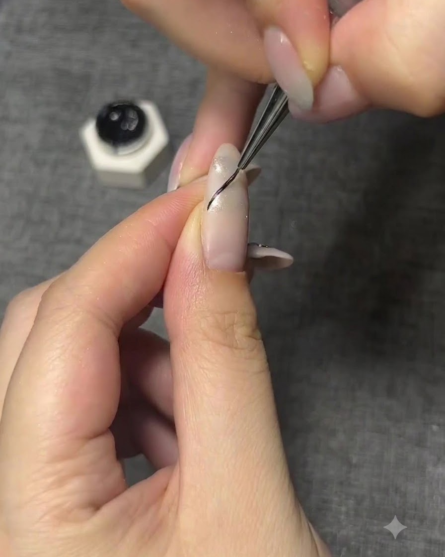 Ein feiner Pinsel zeichnet eine dünne schwarze geschwungene Kontur für einen Schmetterlingsflügel auf einen manikierten Nagel.