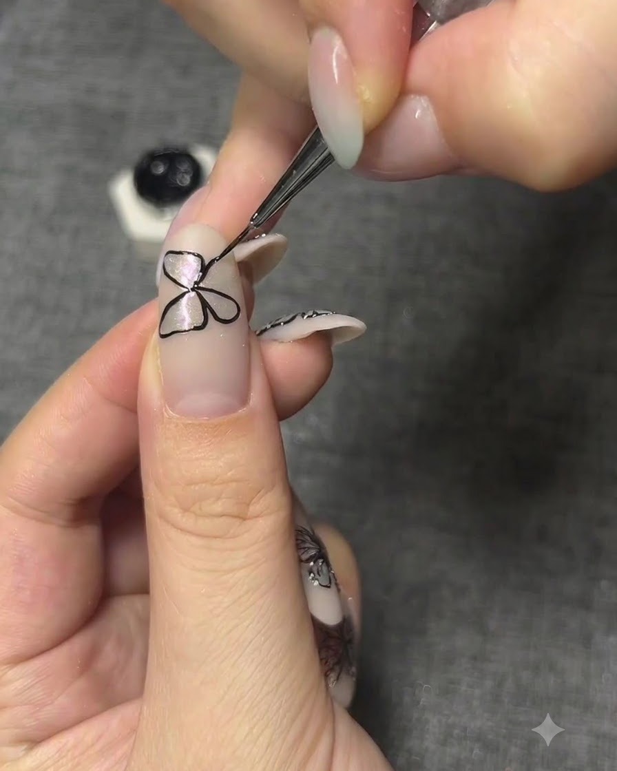 Eine detaillierte Aufnahme, die die genaue Ausrichtung der auf einen Fingernagel gemalten Schmetterlingsflügel anpasst.