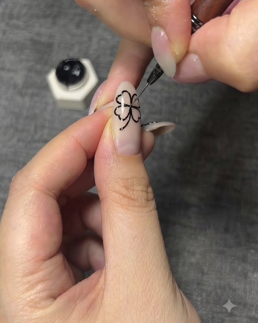 Eine Nahaufnahme eines feinen Nail-Art-Pinsels, der komplizierte schwarze Aderdetails auf die Schmetterlingsflügel zeichnet.