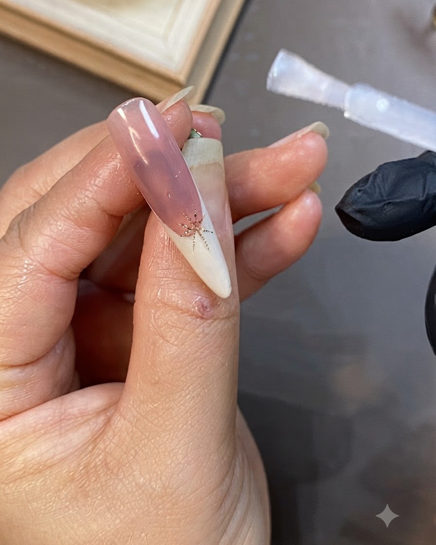 Ein Flaschenpinsel, der klares Aufbaugel über die Oberfläche eines lang dekorierten Nagels aufträgt.