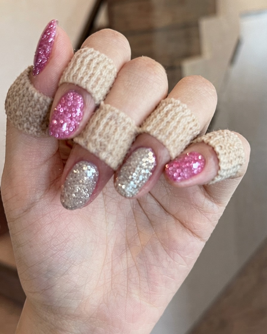Eine Nahaufnahme von Händen, die leicht gedreht sind, um die schimmernde Textur und Reflexion des rosa Diamant-Glittergels zu betonen.