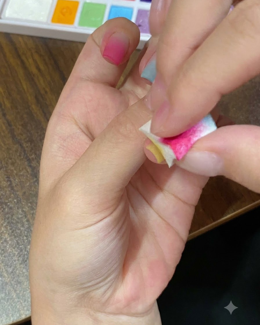 Eine Nahaufnahme eines Schwamm-Applikators, der gelbes Gel auf einen Fingernagel tupft.