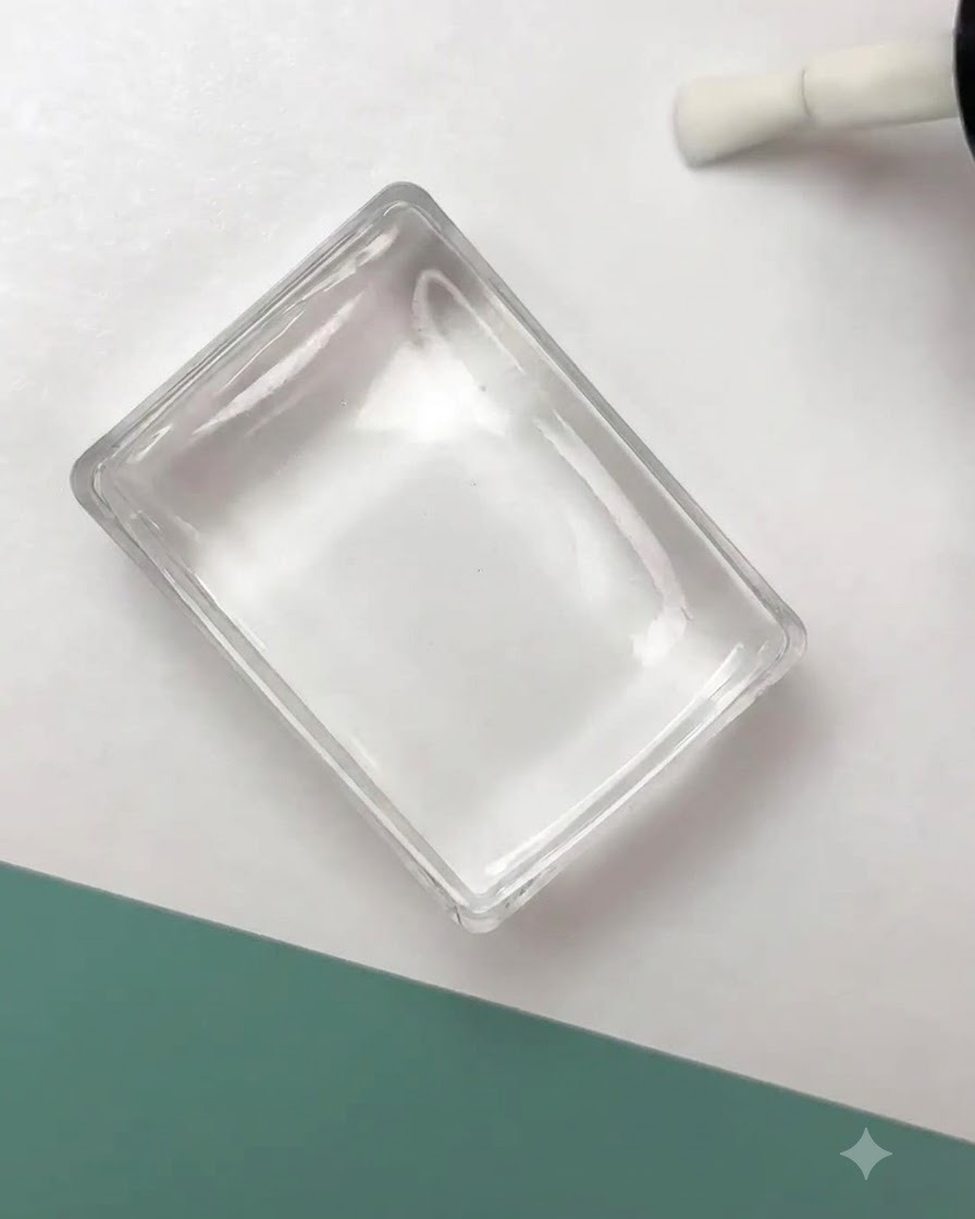 Ein klarer Silikonstempel drückt ein schwarzes Blumen-Umrissdesign auf eine vorbereitete Nageloberfläche.