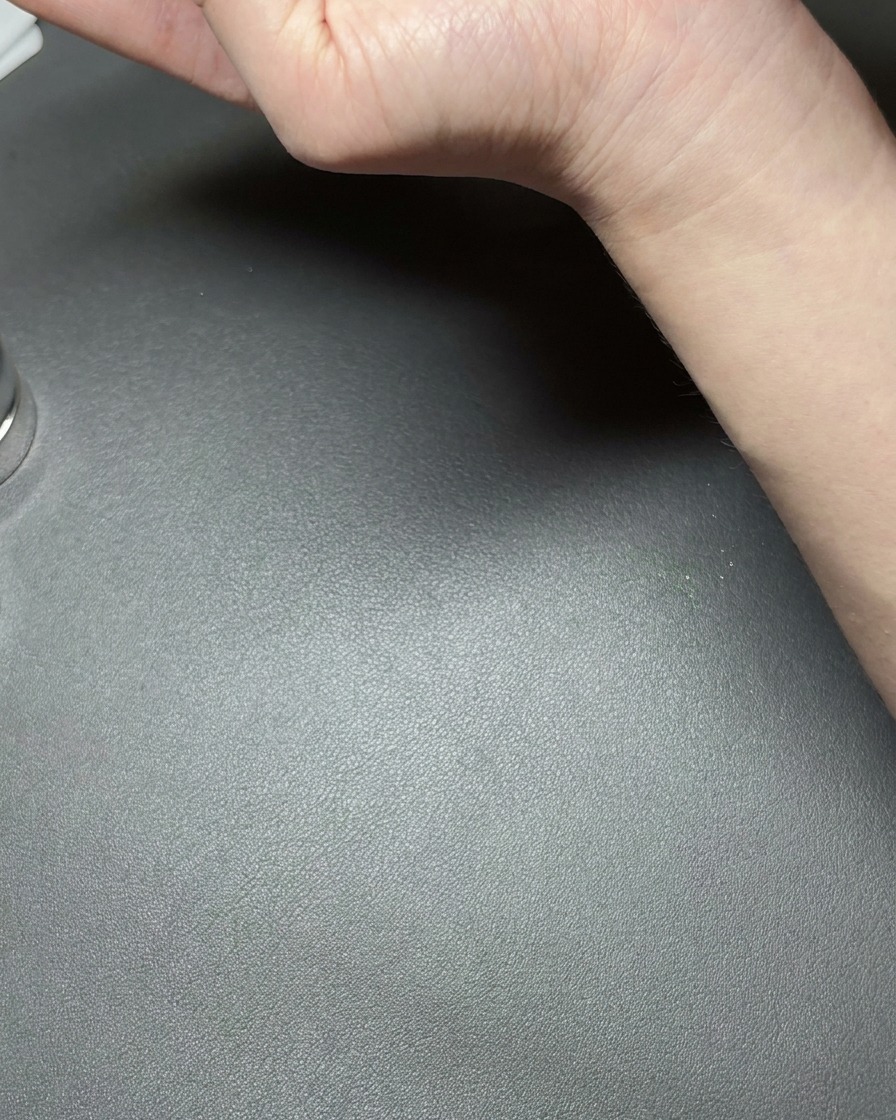 Eine Hand hält einen kleinen Neodym-Magneten nah an einen mit metallic-grünem Cat-Eye-Gel beschichteten Nagel und erzeugt eine helle reflektierende Linie.