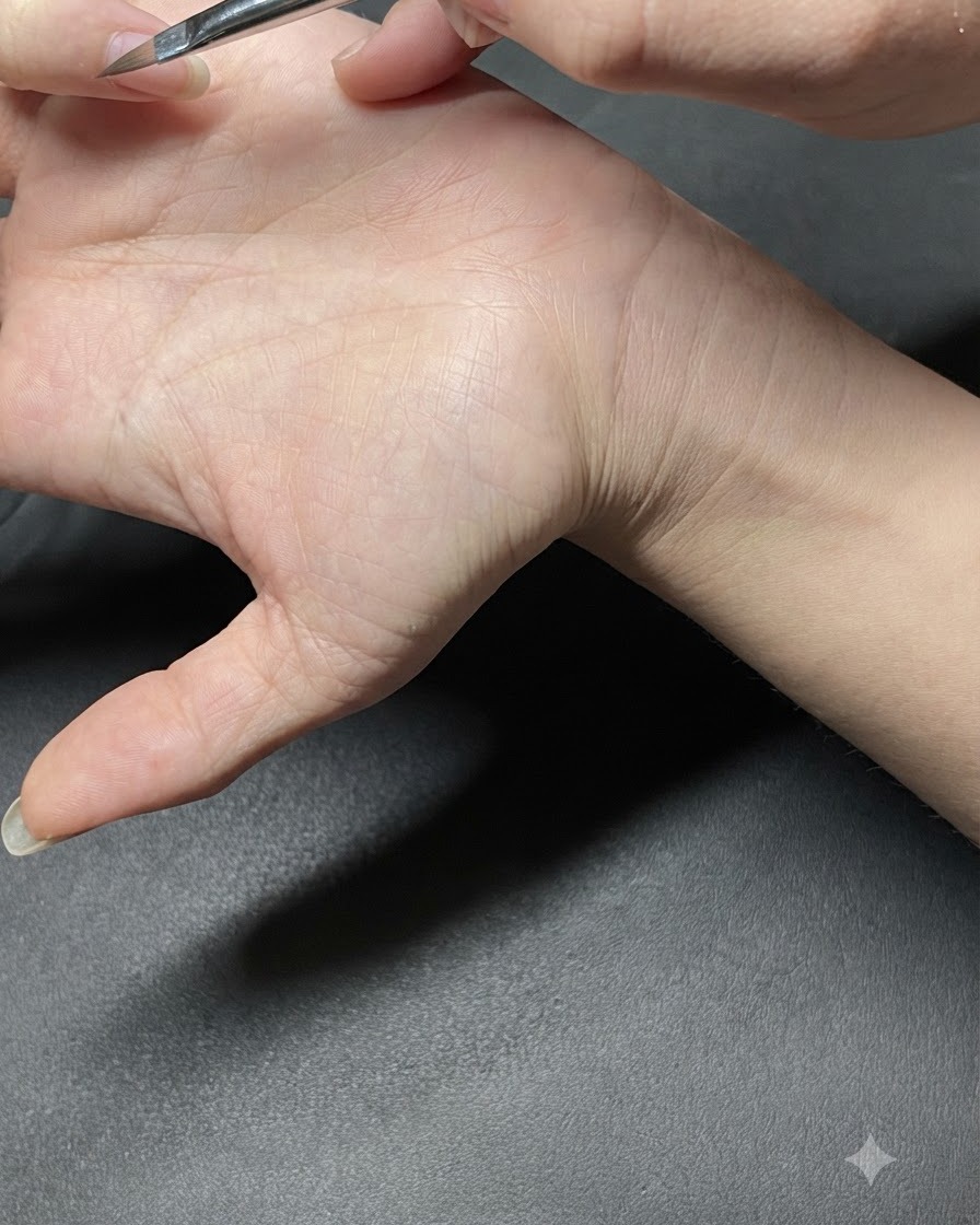 Ein Dotting-Tool setzt kleine mintgrüne Punkte auf einen manikürten Fingernagel.