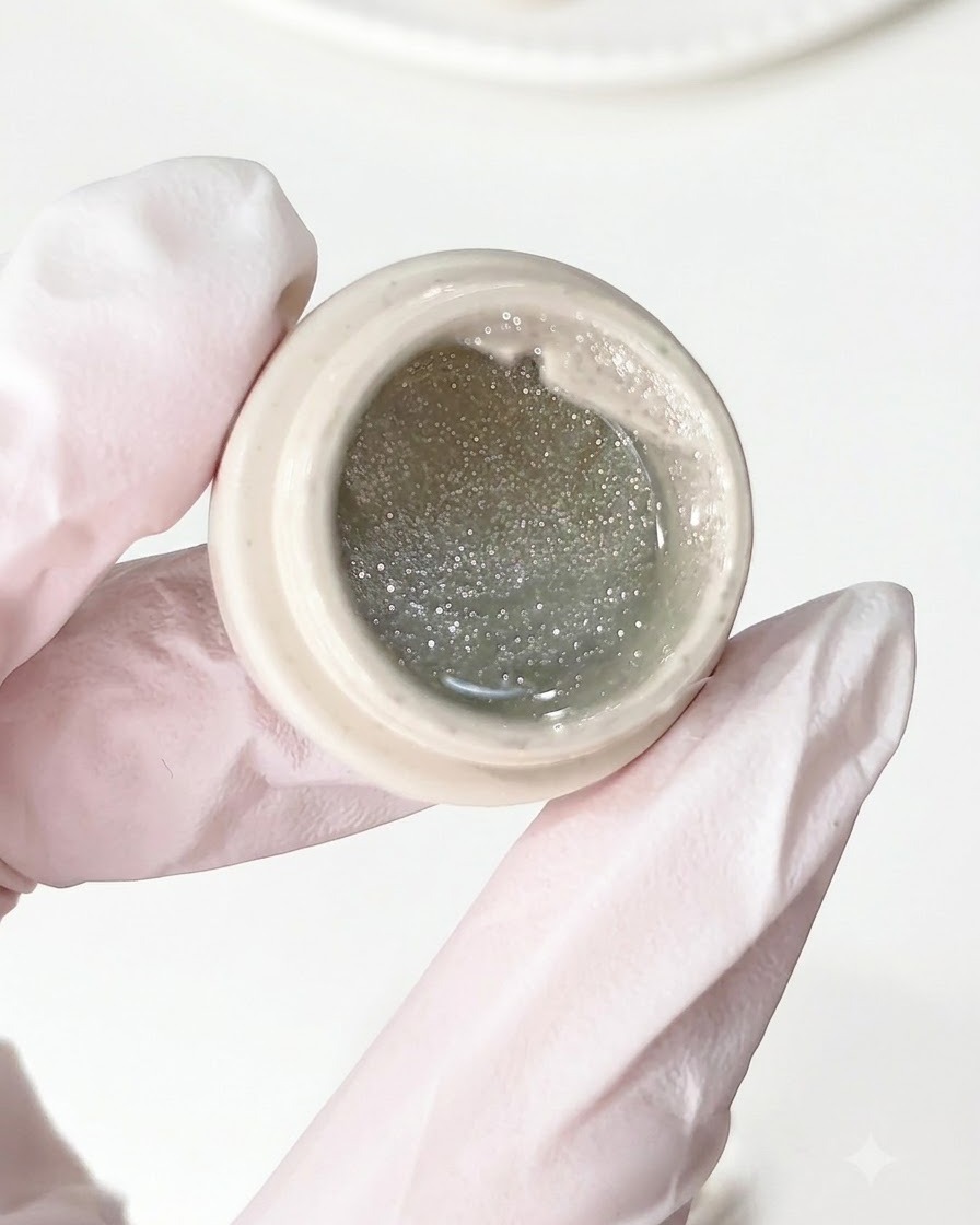 Ein Pinsel trägt Crush-Diamond-Gel auf eine vorbereitete Nagelbasis auf.