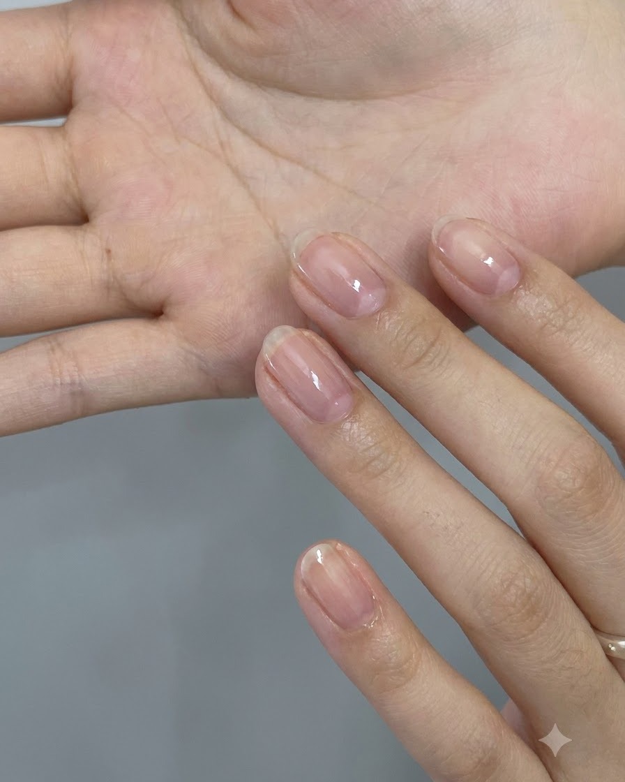 Eine Nahaufnahme einer Hand, die eine Auswahl an holografischen pinken Stern- und herzförmigen Glitterflocken auf der Handfläche hält.