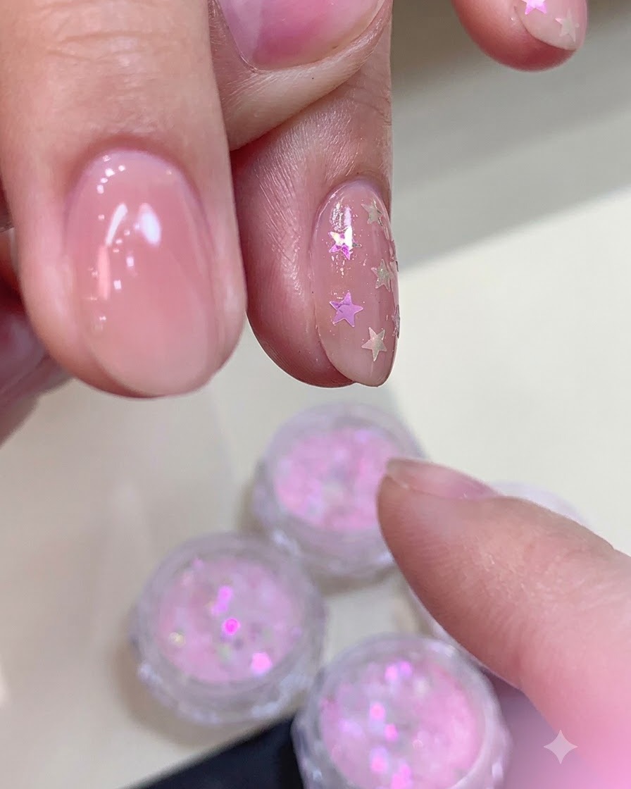 Auftragen einer dicken Schicht matten Top Coats über einen mit vorgebogenem Stern-Glitter dekorierten Nagel.