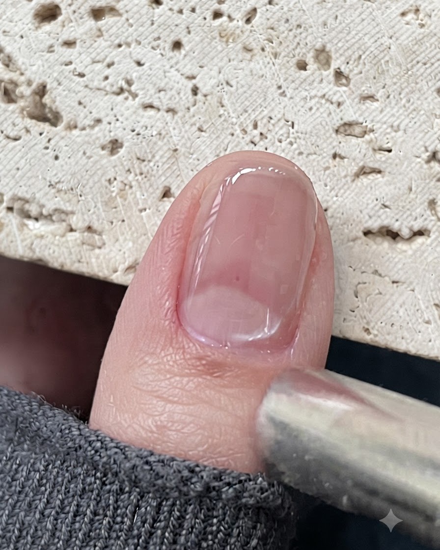 Ein Magnetwerkzeug, das nahe an einem glänzenden Cat-Eye-Gel-Nagel positioniert ist, um die magnetischen Partikel zu ziehen.