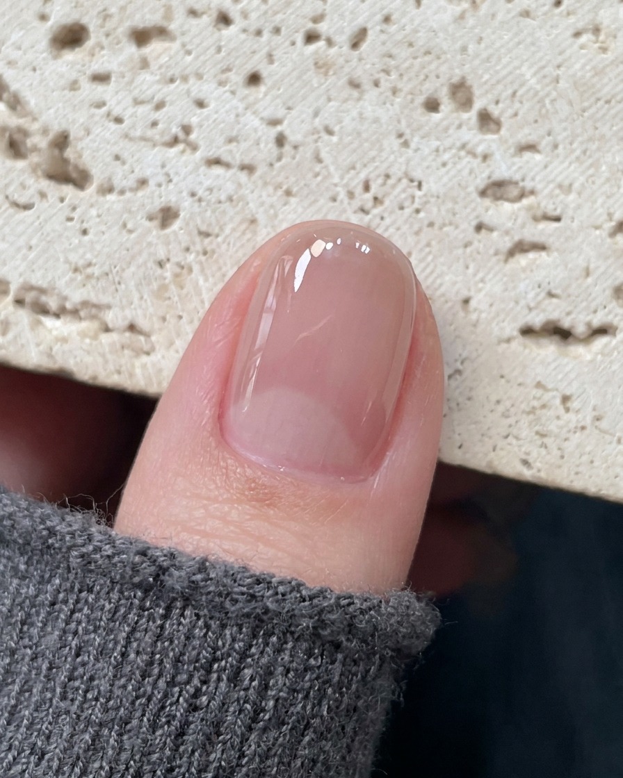 Präzisionspinzetten platzieren einen zarten Hohlstern-Aufkleber auf die Mitte eines ausgehärteten Nagels.