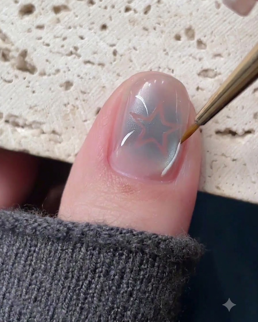 Ein feiner Linerpinsel zeichnet zarte weiße und silberne Linien um ein Hohlstern-Nageldesign.