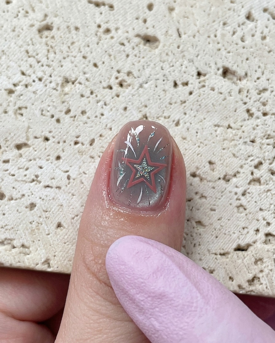 Eine Nahaufnahme zeigt Finger, die mit nährendem Nagelölserum um die Gelenkbereiche massiert werden.