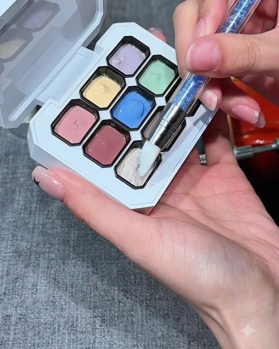 Ein Silikon-Nagelpinsel taucht in eine Mulde mit milchweißem Gel auf einer mehrfarbigen Palette.