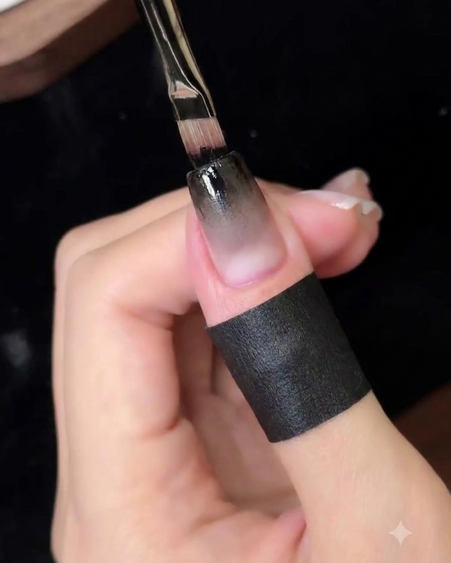 Ein feiner Detailpinsel trägt eine konzentrierte Schicht schwarzen Gels auf die obere Nagel Kante auf.