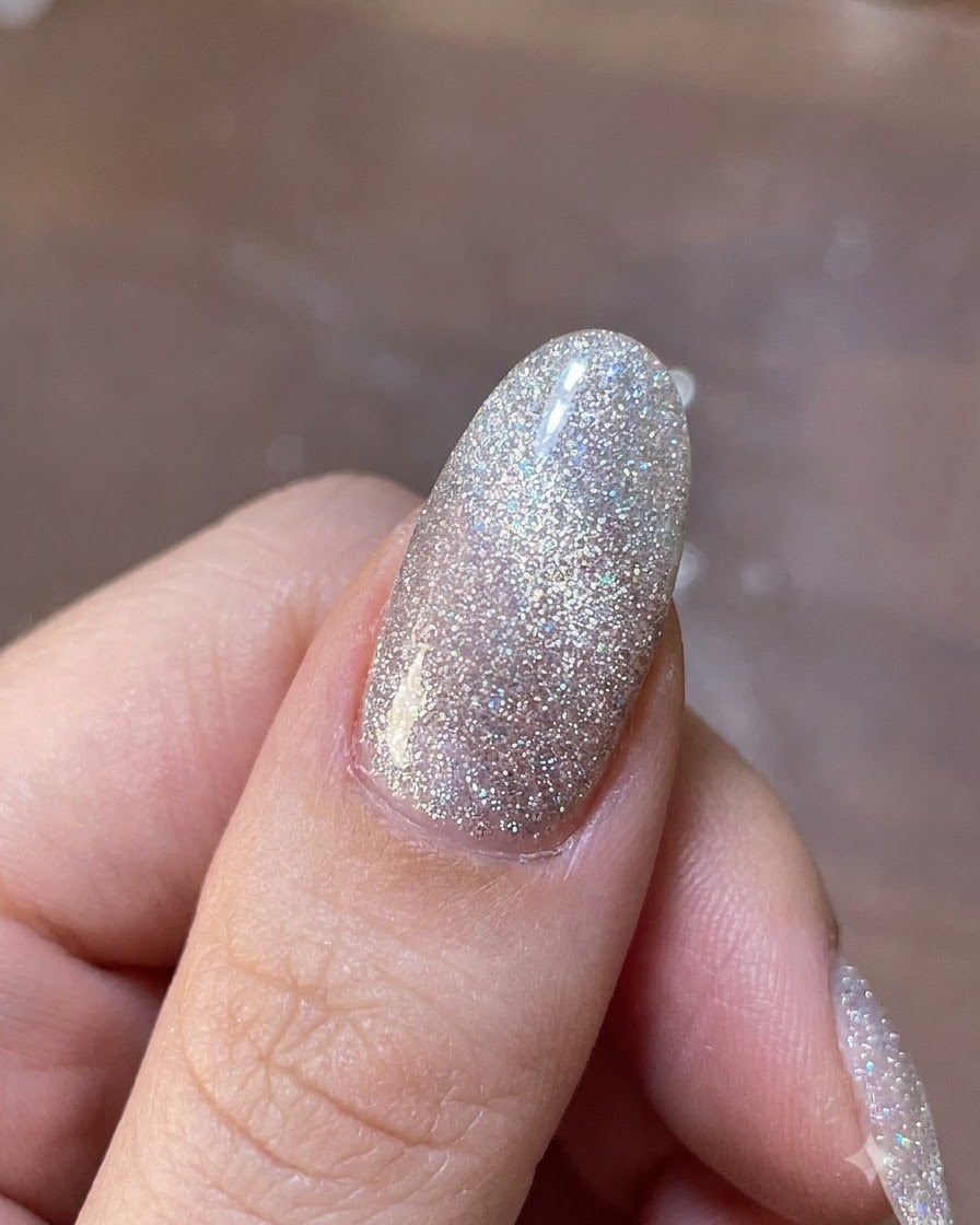 Ein Magnetwerkzeug, das über einem schimmernden Gelnagel schwebt, um die magnetischen Glitterpartikel an ihren Platz zu bewegen.
