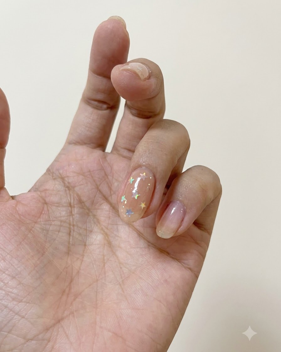 Ein Nagelpinsel trägt matten Top-Coat auf einen mit polarisierten Sternen verzierten Nagel auf.