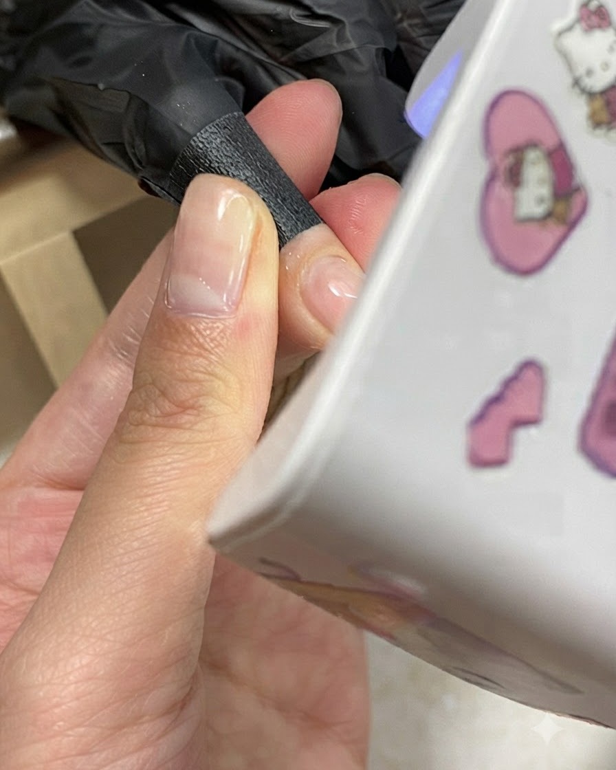 Eine Hand positioniert sich während des Aushärtens unter einer kompakten Mini-UV/LED-Nagellampe.