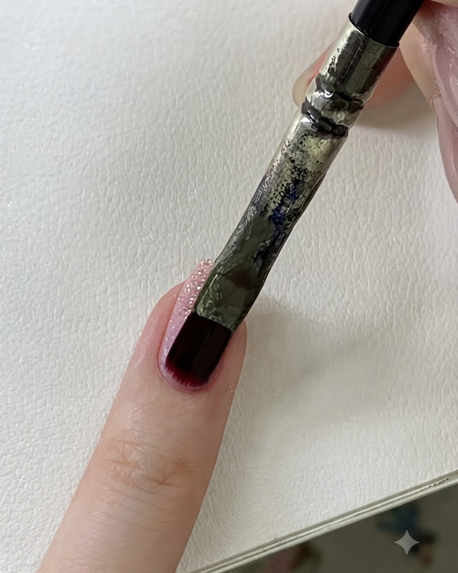 Eine Nahaufnahme des Seitenprofils eines Fingernagels, die die strukturierte Glitzeroberfläche hervorhebt.