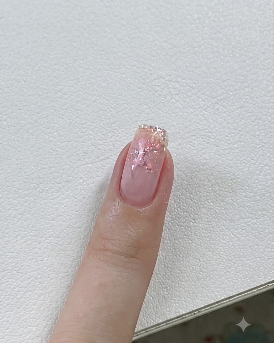 Eine Nahaufnahme eines Fingernagels, der unter einer UV-/LED-Lampe mit rosa Gel- und Sterndetails ausgehärtet wird.