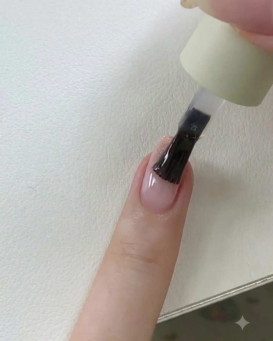 Eine Hand platziert einen Fingernagel mit nassem Top Coat zum finalen Aushärten unter eine UV-/LED-Lampe.