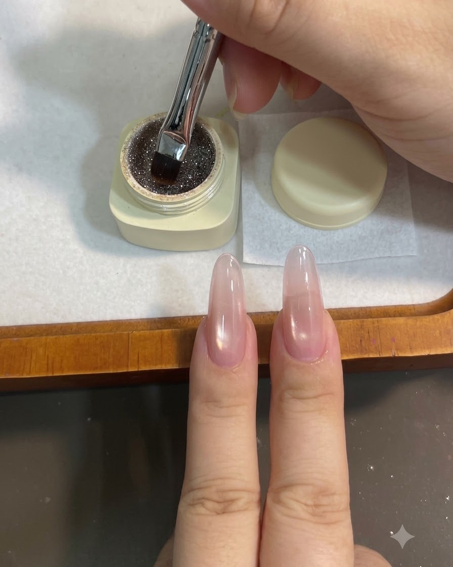 Ein flacher Gelpinsel taucht in einen kleinen Tiegel mit funkelndem braunen kaffeefarbenen Glittergel ein.