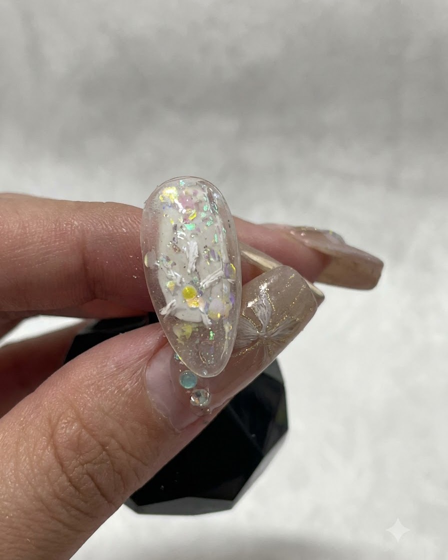 Nahaufnahme eines Nagels, die die ersten weißen Gips-Gel-Striche zeigt, die den Beginn eines floralen Designs bilden.