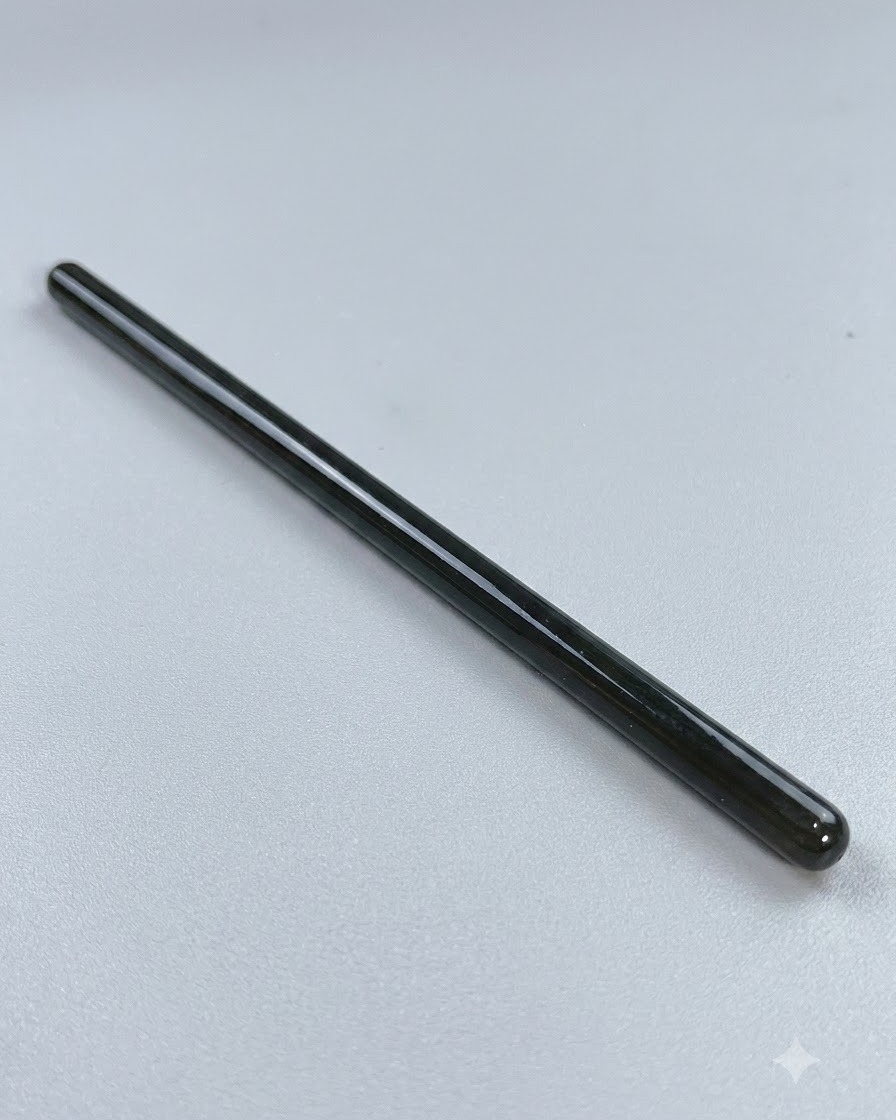 Ein langer, feiner Nagelkunstpinsel ruht vor detaillierten Linienarbeiten auf einer sauberen Oberfläche.
