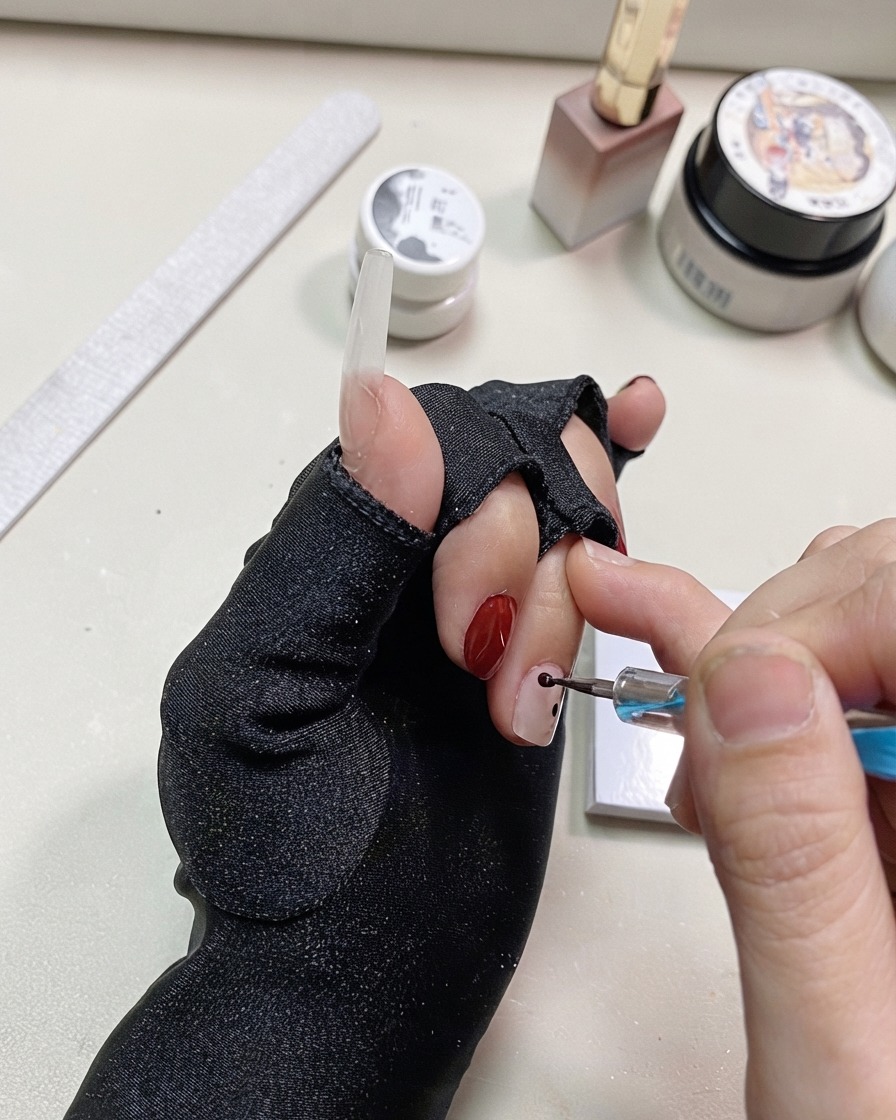 Ein Dotting Tool fügt weitere schwarze Punkte in der Nähe der vorherigen Punkte auf dem Nagel hinzu.