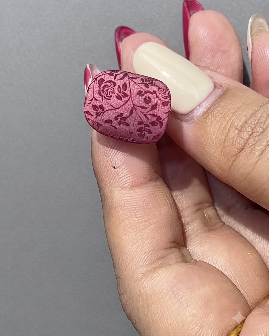 Eine Hand hält eine Flasche rotes Cat-Eye-Gel neben einem klaren Nagelpräsentationsständer.