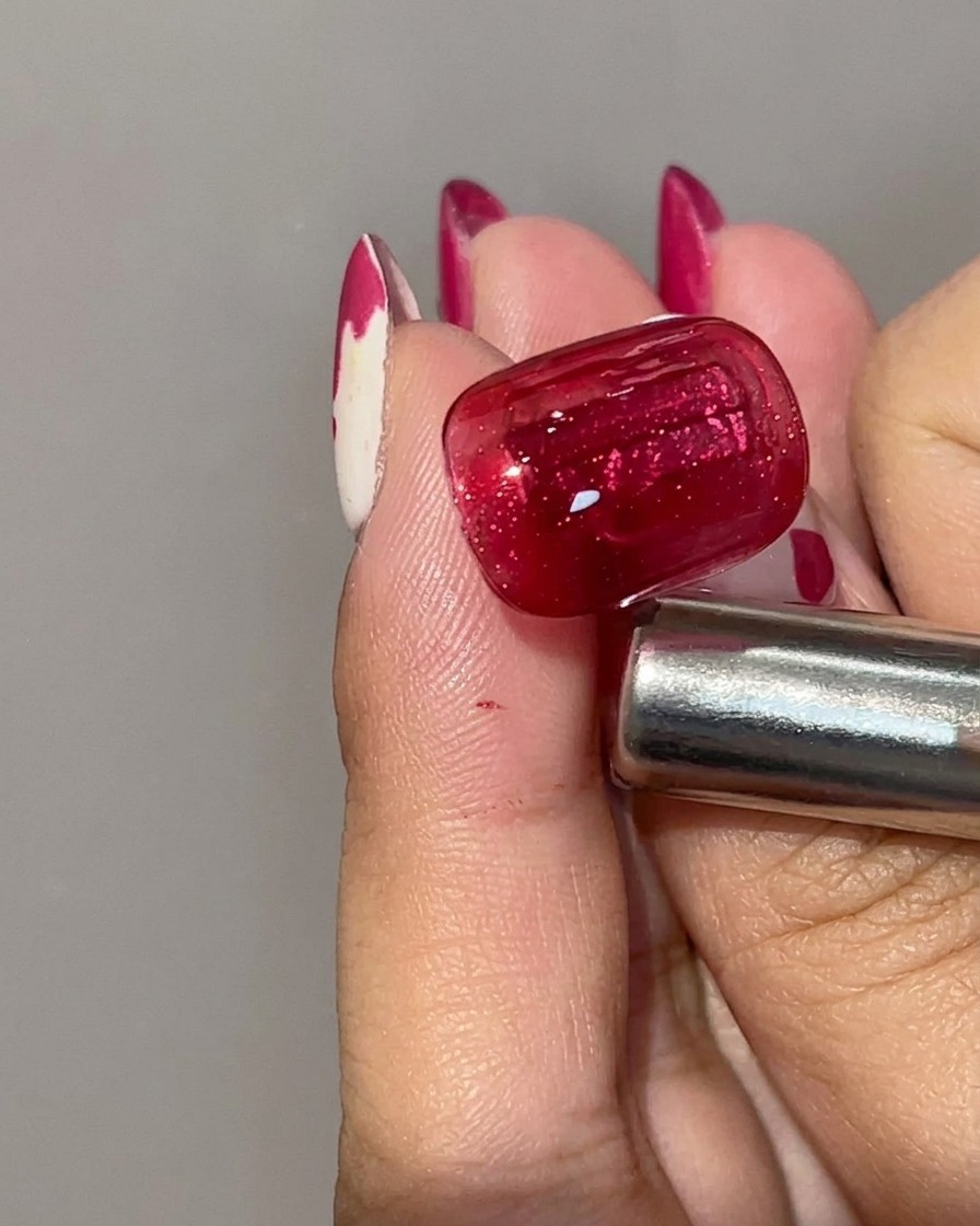 Nahaufnahme eines ausgehärteten roten Cat-Eye-Gel-Nagels mit tiefer karmesinroter Basisfarbe und konzentriertem Magnetlichtstreifen.