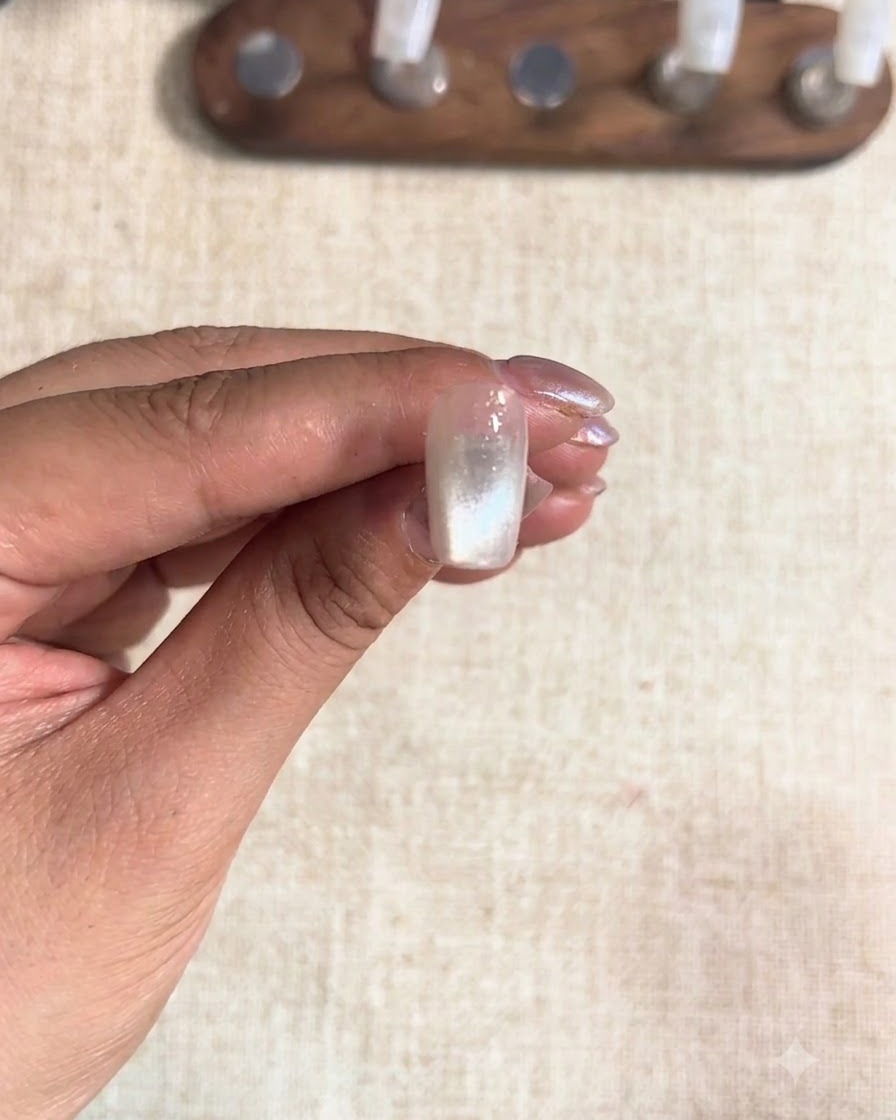 Ein unter einer Lampe ausgehärteter Mittelfingernagel, der ein fixiertes Cat-Eye-Finish zeigt.