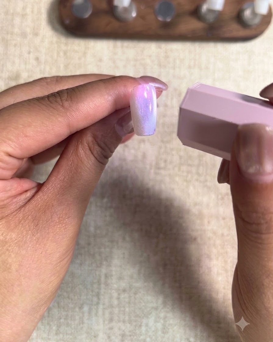 Eine Nahaufnahme eines Pinsels, der pfirsichfarbenes Nude-Gel auf einen Zeigefingernagel aufträgt.