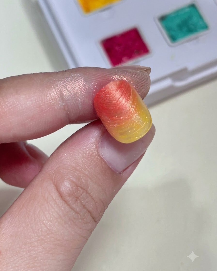 Eine Nahaufnahme, die eine strukturierte Farbverlaufs-Nagelspitze hält und die Form sowie Farbe des Hintergrunds zeigt, bevor Charms hinzugefügt werden.