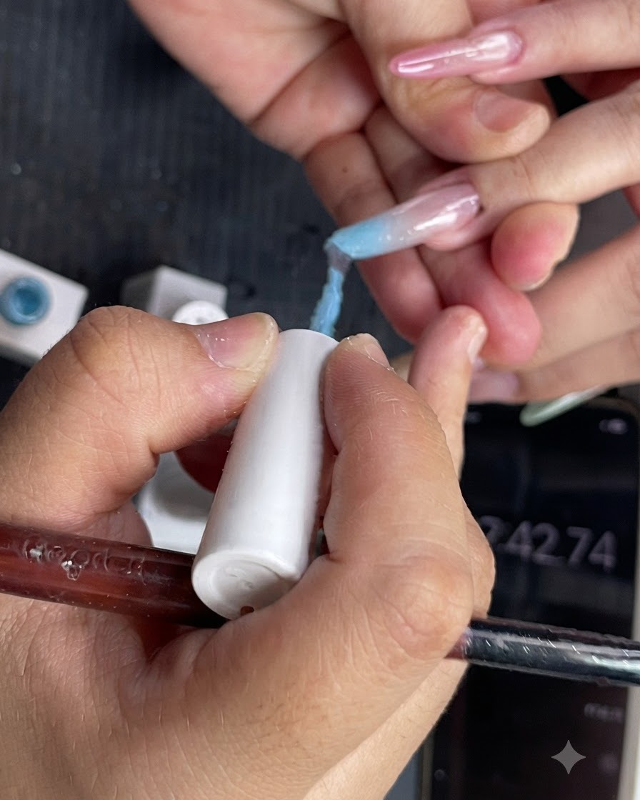 Nahaufnahme von hellblauem Gel-Nagellack, der auf die obere Hälfte eines Fingers aufgetragen wird.