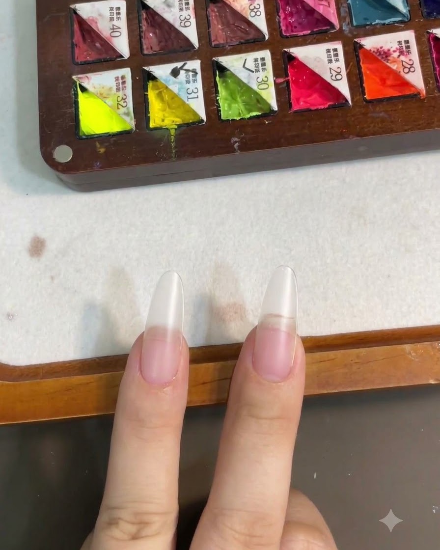 Nägel nach dem Aushärten der Base-Coat-Schicht unter einer Nagelampe.