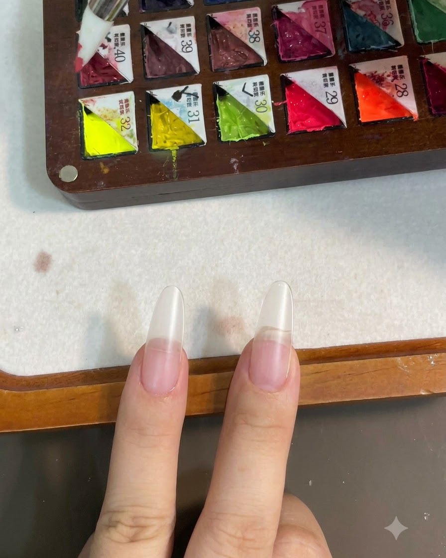 Ein Silikonpinsel nimmt rosa Gelfarbe von einer unterteilten Palette auf.