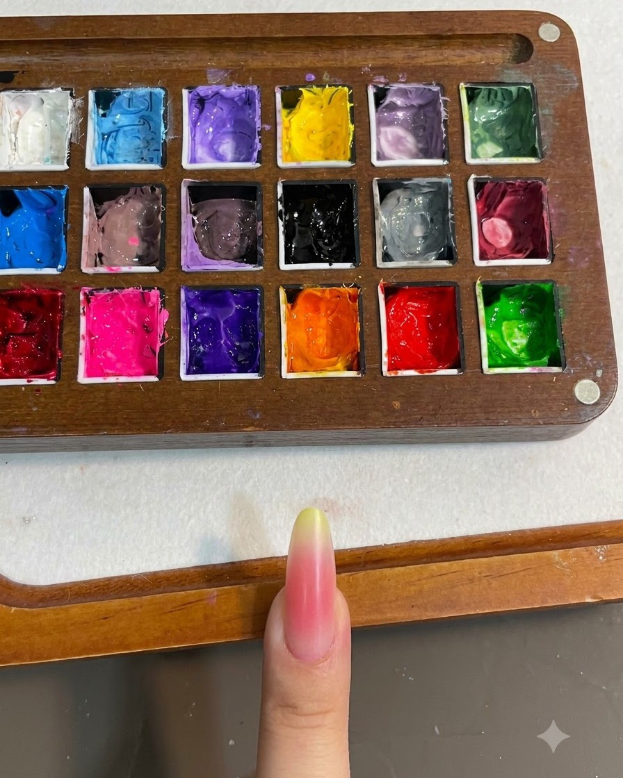 Eine Nahaufnahme eines Nagels mit rosa und gelbem Farbverlauf, der unter einer Nagellampe ausgehärtet wird.