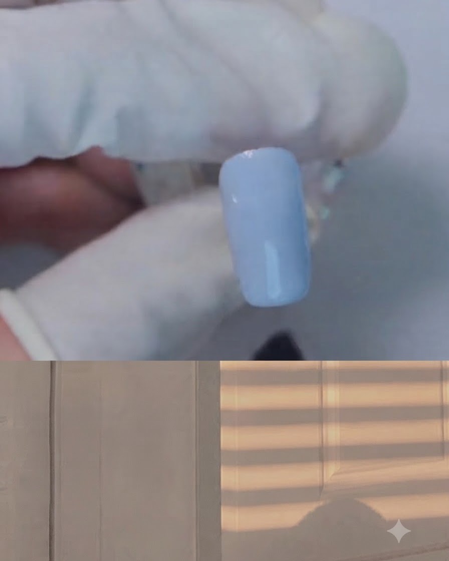 Ein Pinsel, der klares Blooming-Gel über einen hellblauen Nagel aufträgt.