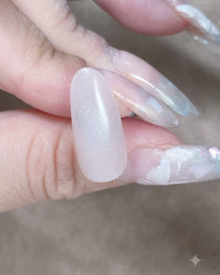 Nahaufnahme eines Make-up-Schwamms, der entlang der Nagelhaut und des Seitenrandes tupft, um eine Gel-Basisschicht zu verblenden.