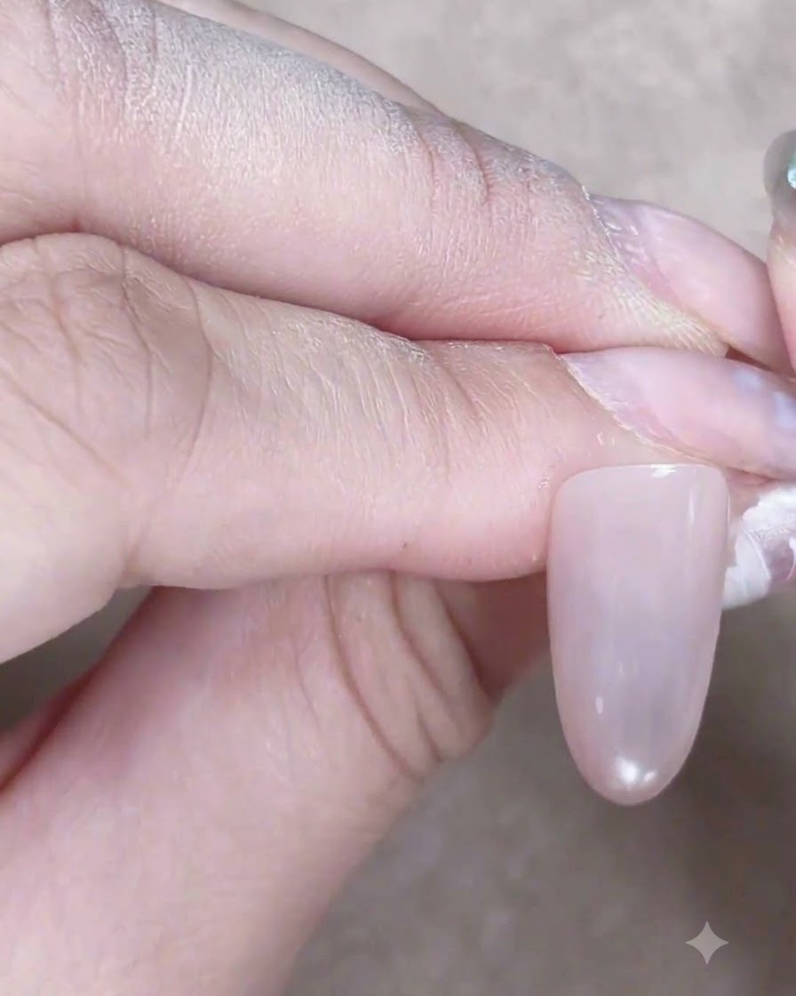 Ein Nagel mit einem zentralen, leuchtenden Glaskugel-Highlight, das durch das Einstellen eines Magneten über Cat-Eye-Gel erzeugt wurde.