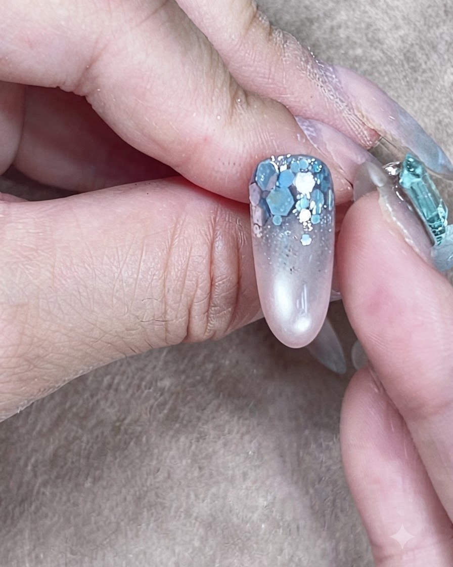 Eine fertige Nagelstruktur mit selbstverlaufenem klarem Aufbaugel, das die Glitzer-Nail-Art umschließt.