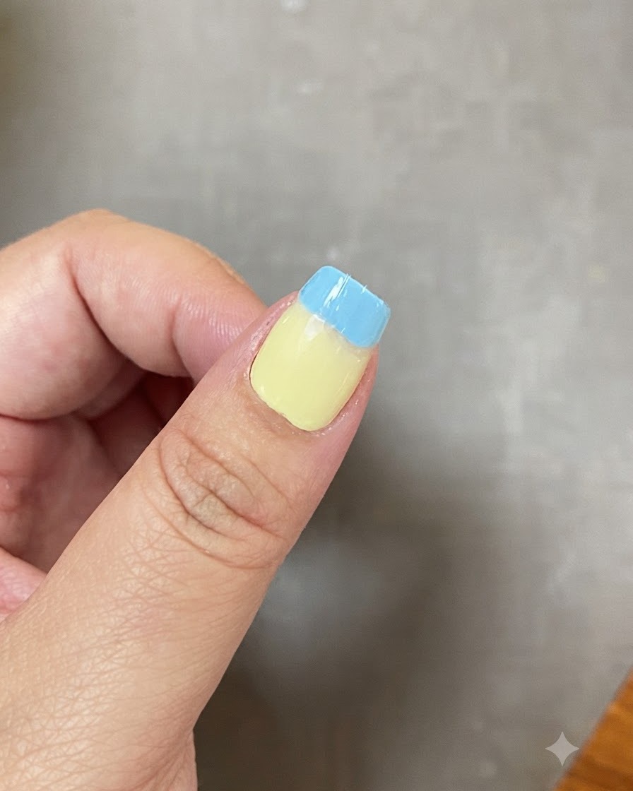 Ein Fingernagel mit einem verblendeten Farbverlauf zwischen Hellgrün und Hellblau.