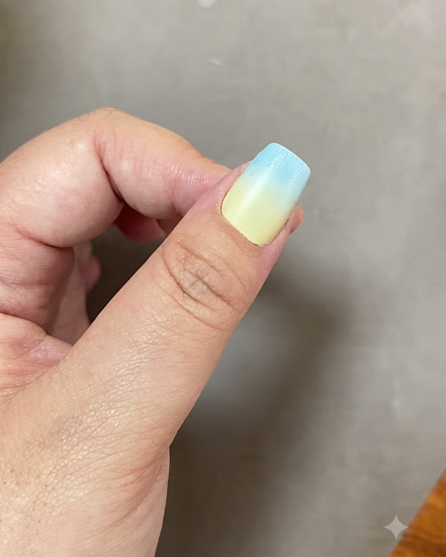 Ein Fingernagel mit einem Blau-Gelb-Farbverlauf im Inneren einer UV-LED-Lampe.