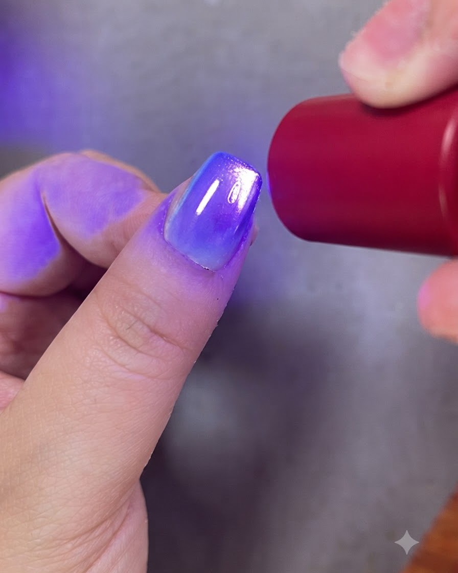Ein Pinsel trägt klaren Top Coat über ein fertiges Gradienten- und Cat-Eye-Geldesign auf.