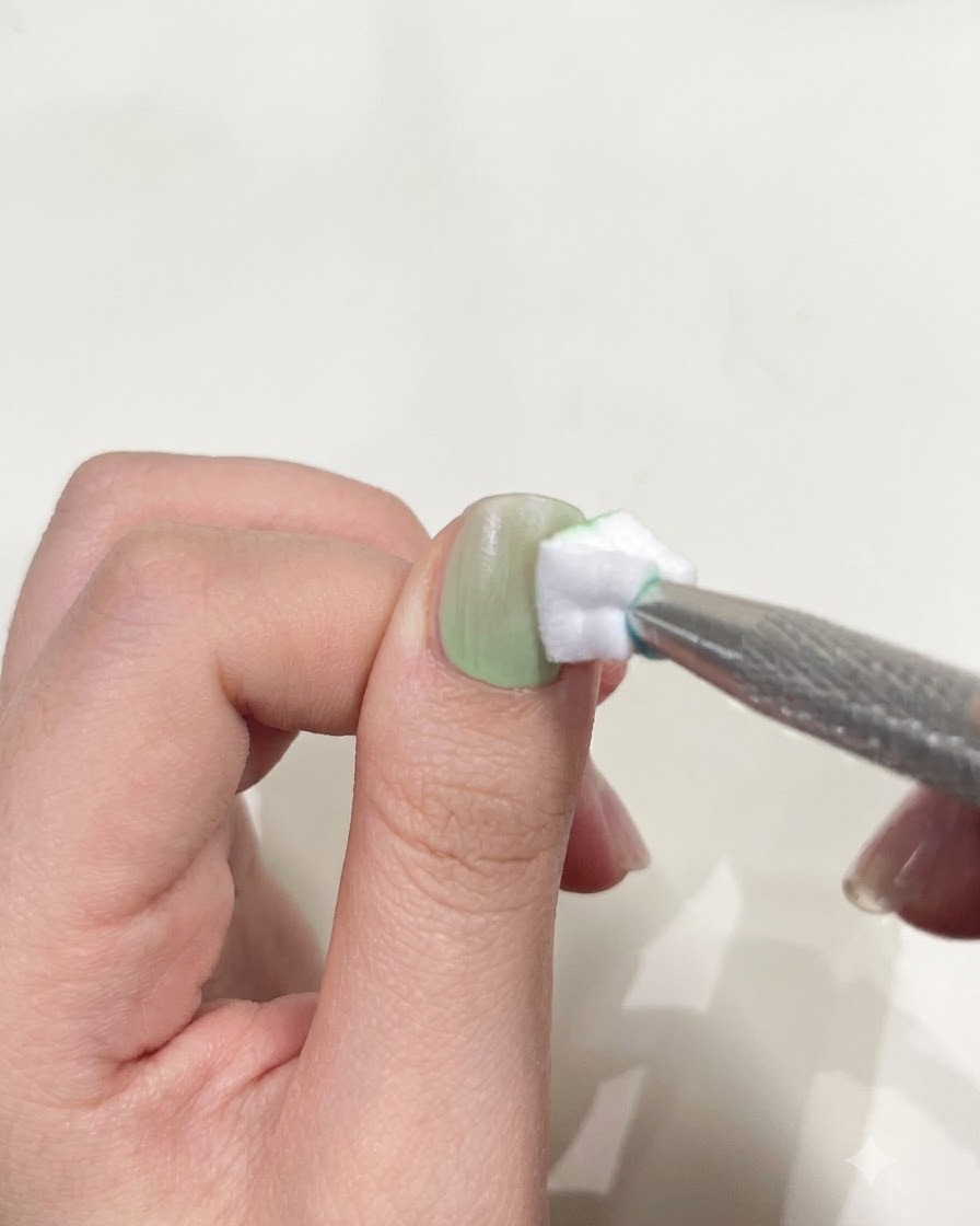 Ein Daumen unter einer kompakten Mini-UV/LED-Taschenlampe zum Aushärten von UV-Nagellack.