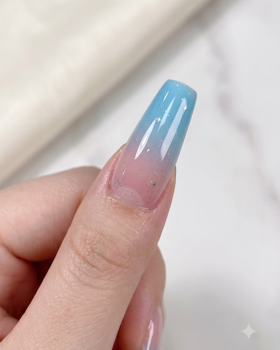 Ein Finger mit einem Farbverlauf-Nagel und zarten silbernen Sternakzenten liegt unter einer UV-/LED-Lampe zum Aushärten.
